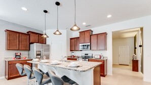 A modern kitchen with granite countertops, stainless steel appliances, and wooden cabinets. - 5280oak Luxury Ne 6 Bedroom 4.bath Home (Davenport)