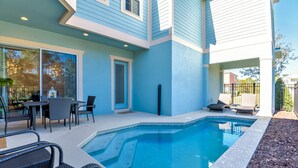 Ett modernt hus med en swimmingpool, utemöbler och en uteplats.