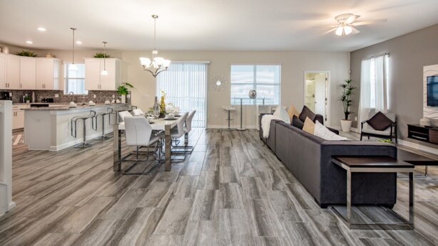 A modern kitchen with a dining area, a living room with a sofa, and a ceiling fan. - 9044st00 Premium-lot Location (Davenport)