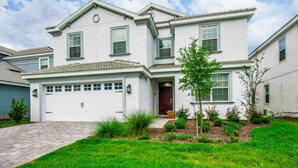 A two-story house with a white exterior, a garage, and a well-maintained front yard with grass and shrubs. - 9044st00 Premium-lot Location (Davenport)