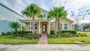 A two-story house with a front porch, palm trees, and a brick pathway leading to the entrance.