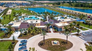 An aerial view of a resort with a large pool, multiple buildings, and a parking area. - 9031 Pelican (Kissimmee)