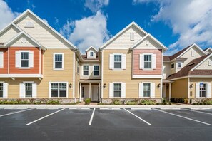 A row of townhouses with a parking lot in front.