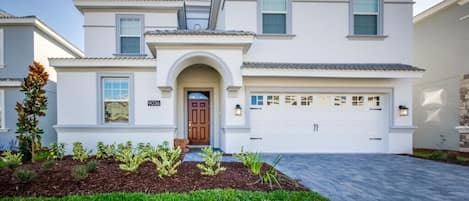 A two-story house with a front entrance, garage, and a well-maintained lawn.