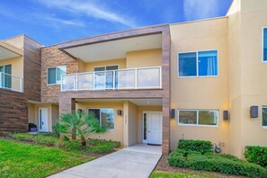 A modern multi-story residential building with a flat roof, large windows, and a balcony. - New Magic Villa Resort Townhome 3123bra (Kissimmee)