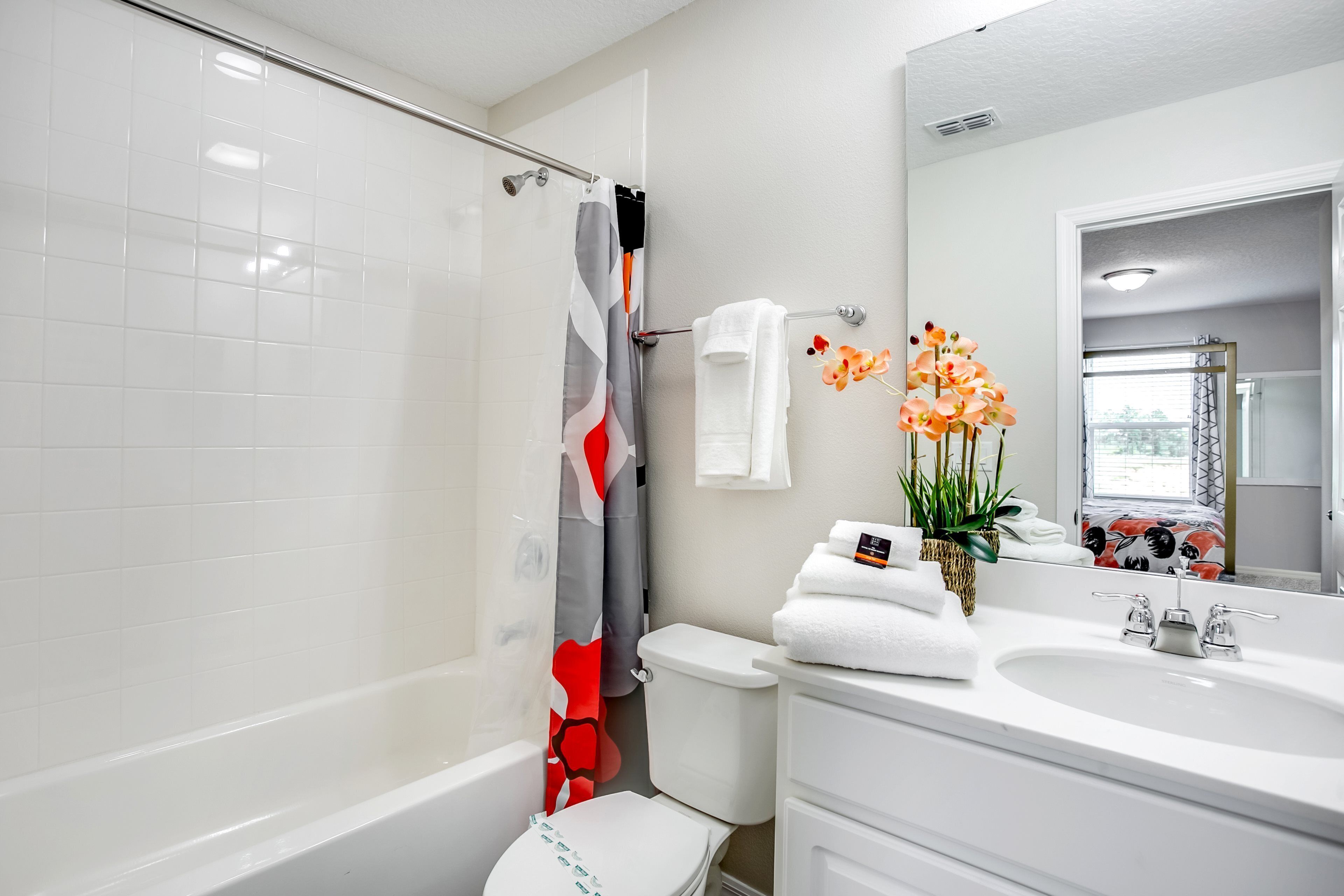 A modern bathroom with a bathtub, toilet, and sink.