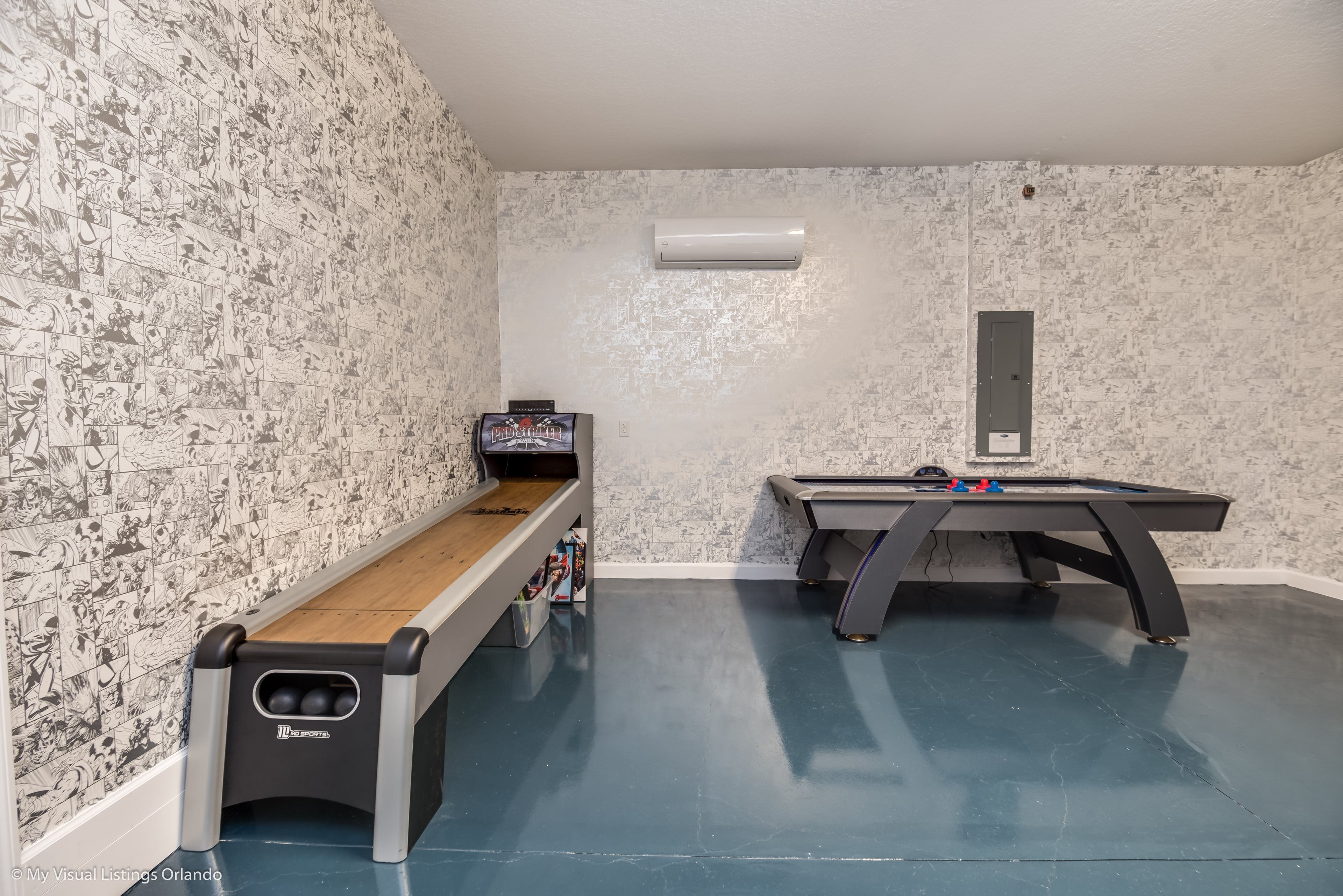Une pièce équipée d’une table de billard, d’un baby-foot et d’un long banc avec espace de rangement.