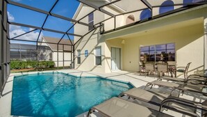 A pool area with lounge chairs and a covered seating area.
