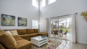 A living room with a brown sofa, a white coffee table, and two abstract paintings on the wall.