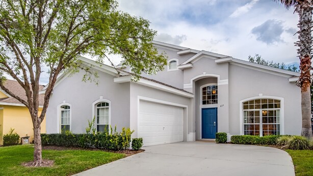 A single-story house with a white exterior, a blue front door, and a garage. - 435castle (Davenport)