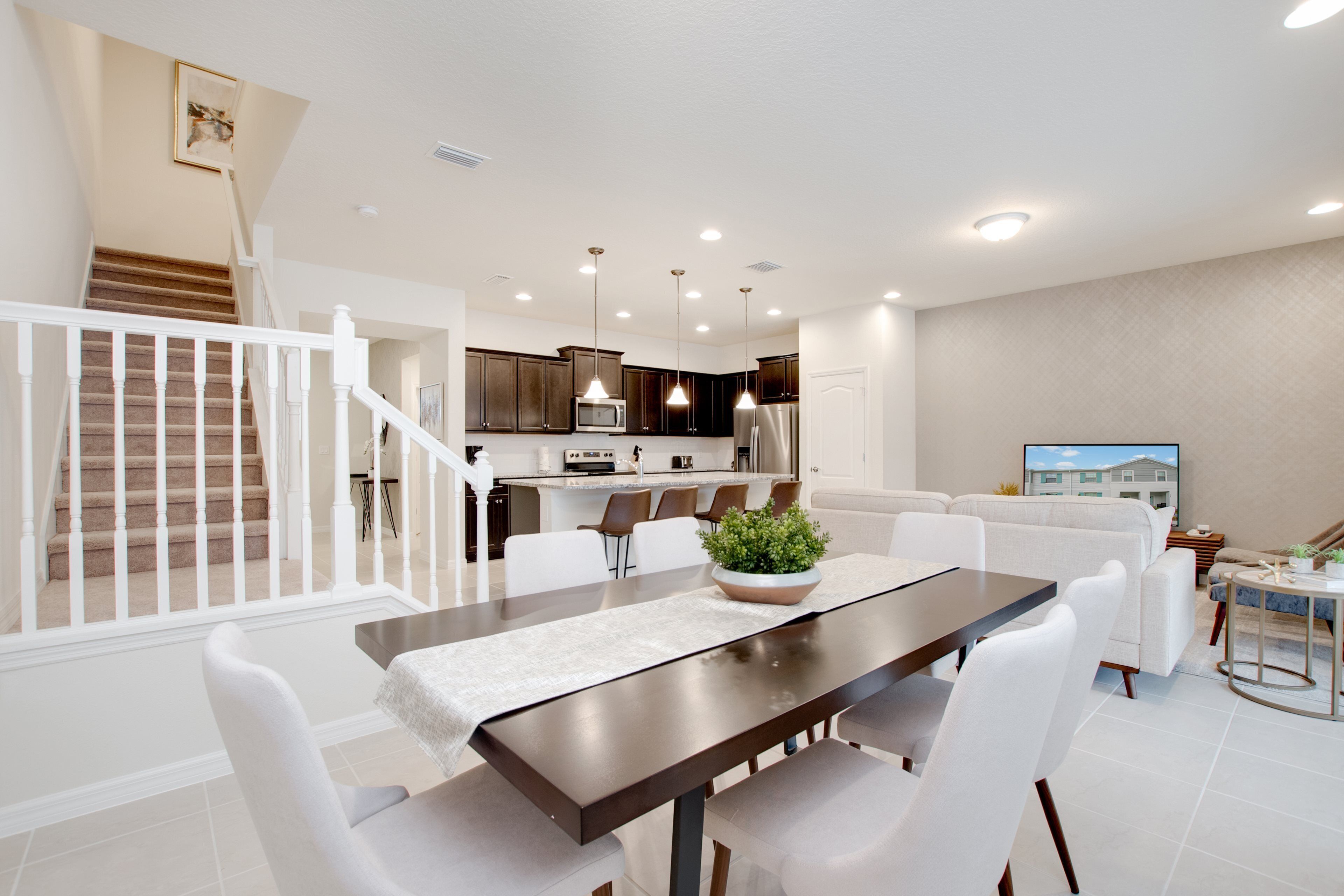 A modern kitchen with dark cabinets, a central island, and pendant lighting.
