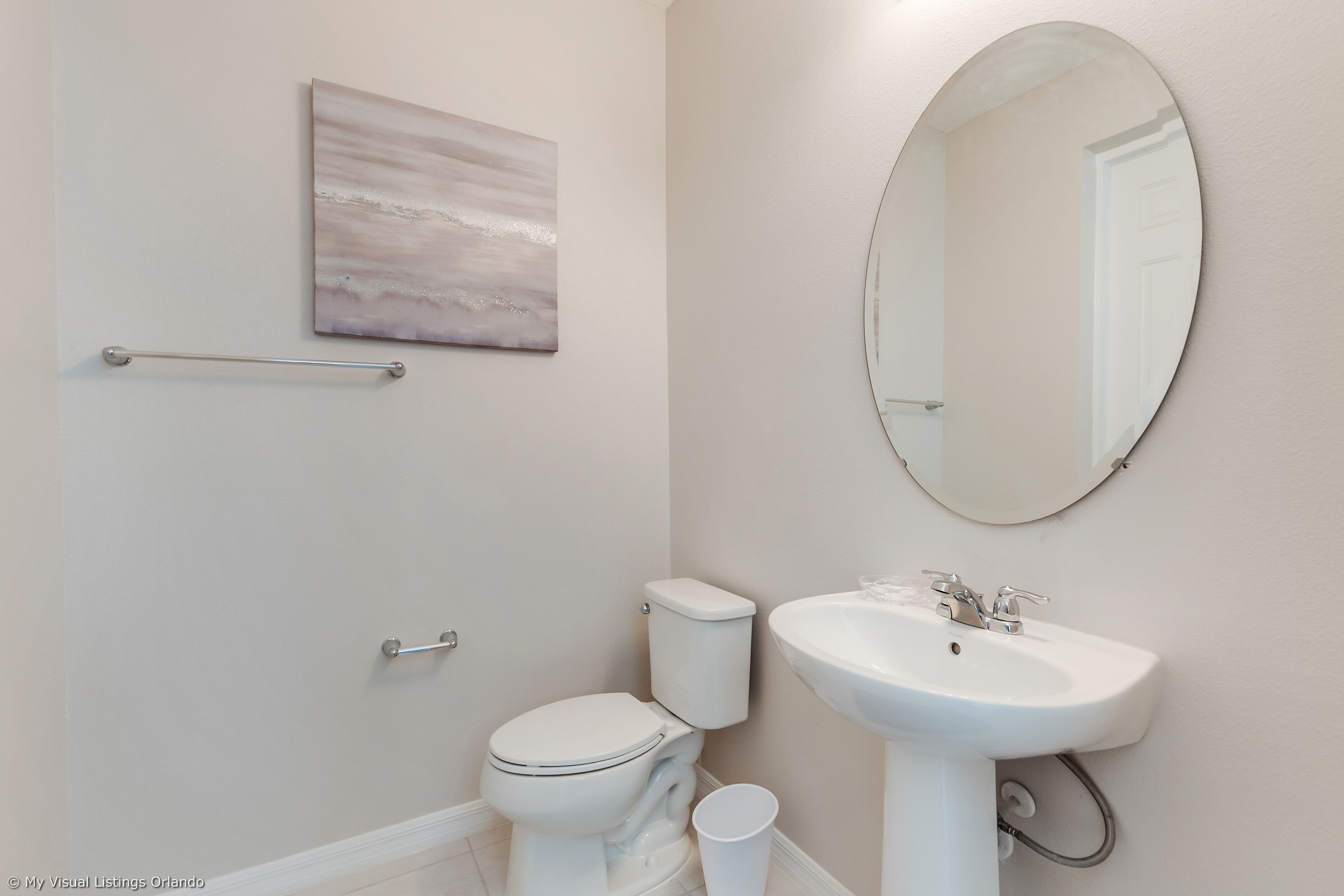 Een badkamer met toilet, wastafel en spiegel.