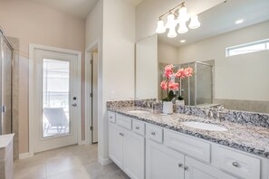A bathroom with a large mirror, a sink, and a shower. - 8917bengal Sleeps 20 (Kissimmee)
