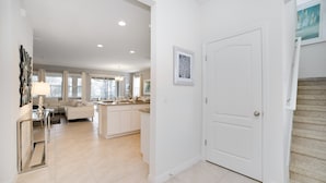 A spacious, well-lit interior with a kitchen, dining area, and living room. - 5 Bdrm Solterra New Home (Davenport)