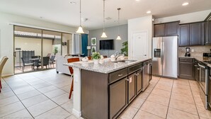 A modern kitchen with granite countertops, stainless steel appliances, and pendant lighting. - 1939majorca Fantastic 5 Bed 4 Bathroom Town Home (Kissimmee)