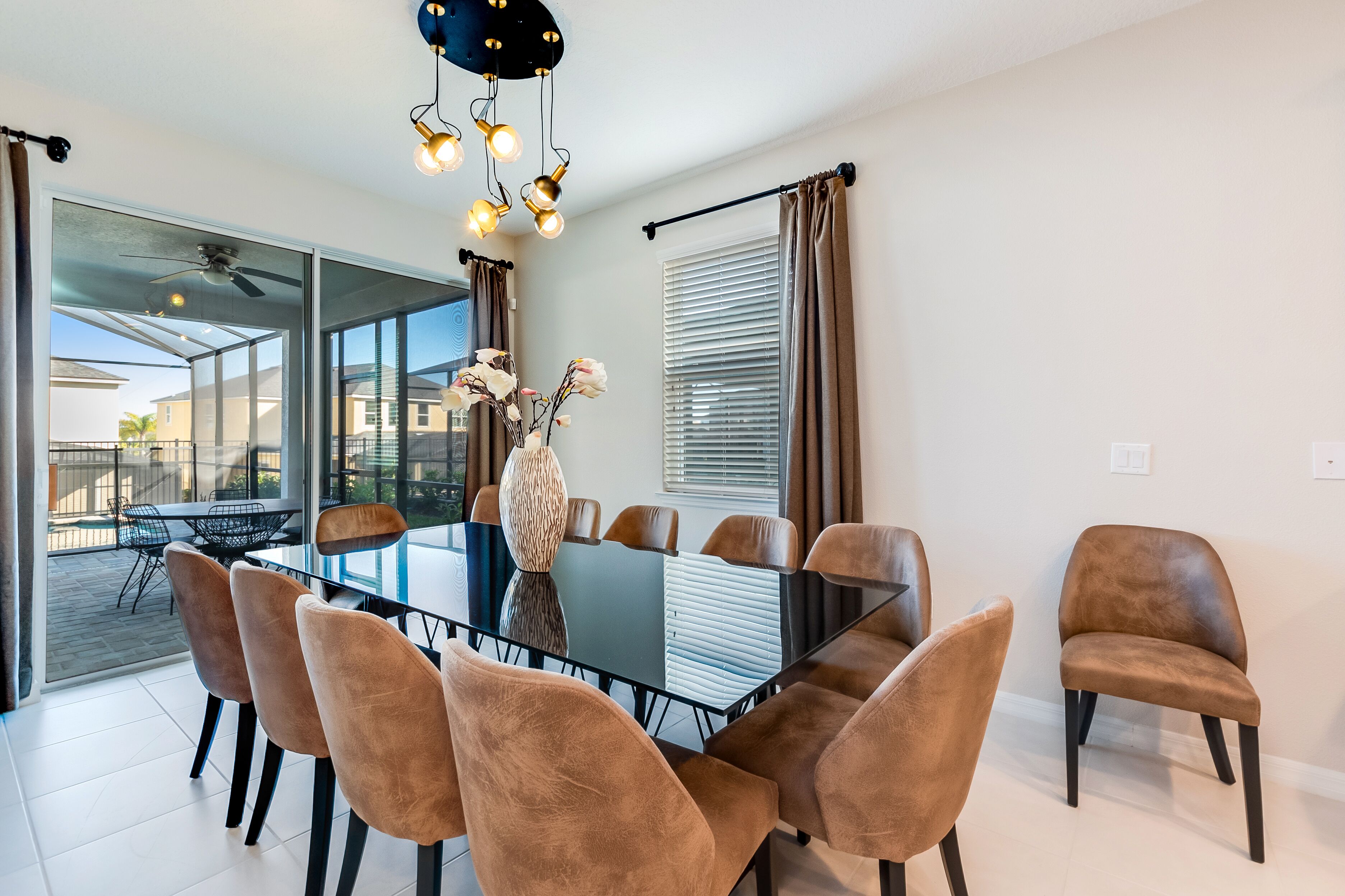 Un área de comedor moderna con una mesa de vidrio, sillas marrones y un jarrón decorativo.