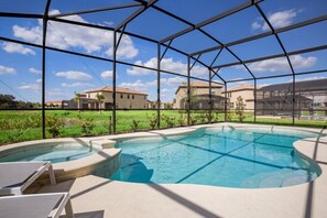 Piscina com área coberta, rodeada por uma estrutura metálica, e vista para edifícios residenciais ao fundo.
