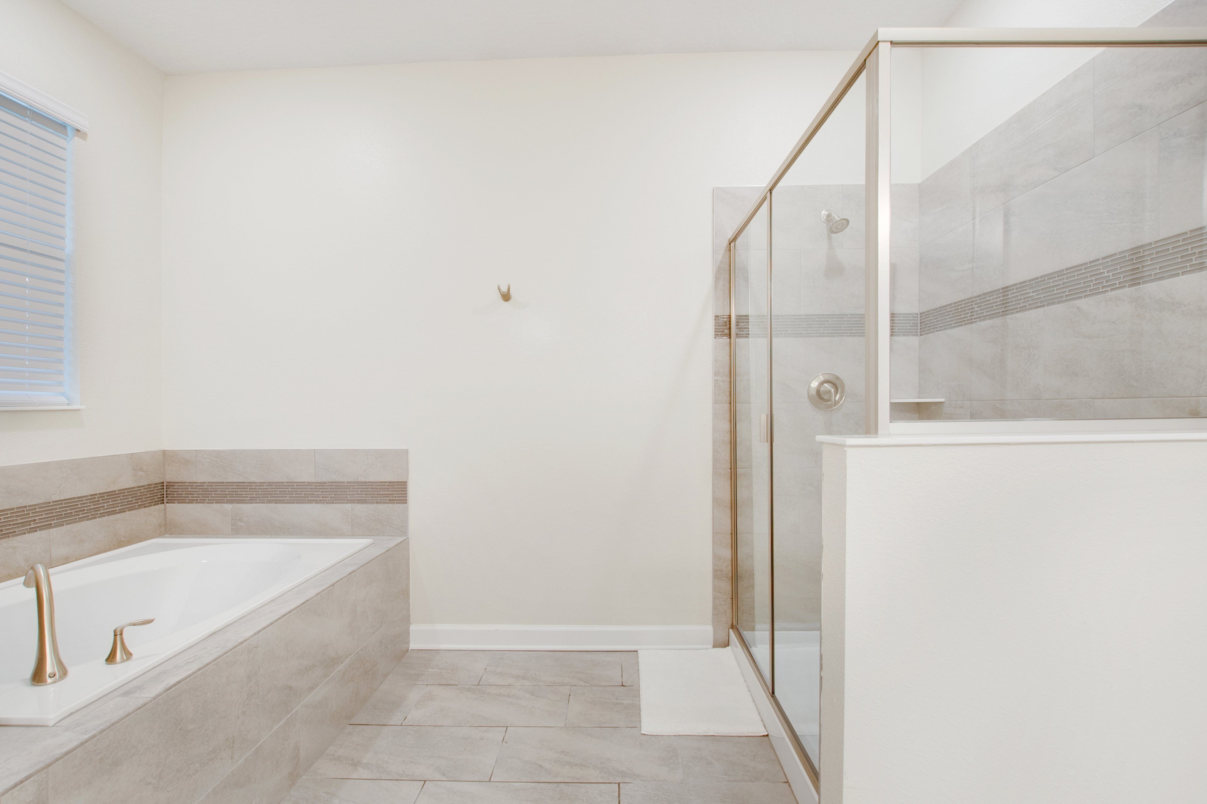 A modern bathroom with a bathtub, shower, and glass-enclosed shower area.