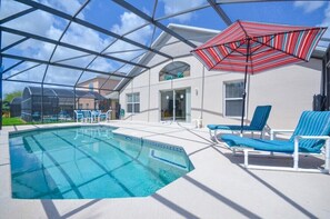 A swimming pool with lounge chairs and a red-striped umbrella. - 8524phd (Kissimmee)