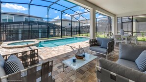 A pool area with a glass enclosure, outdoor furniture, and a hot tub. - 9 Bed 6,5 Ba Villa Games, Pool & Spa (Kissimmee)