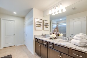 A modern bathroom with a double vanity, a large mirror, and a vanity with a sink and towel stack. - 5bed 5Ba Villa Game Room Pool Spa (Kissimmee)