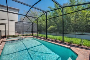 A swimming pool with a clear blue water, surrounded by a brick border and a metal fence. - 5bed 5Ba Villa Game Room Pool Spa (Kissimmee)