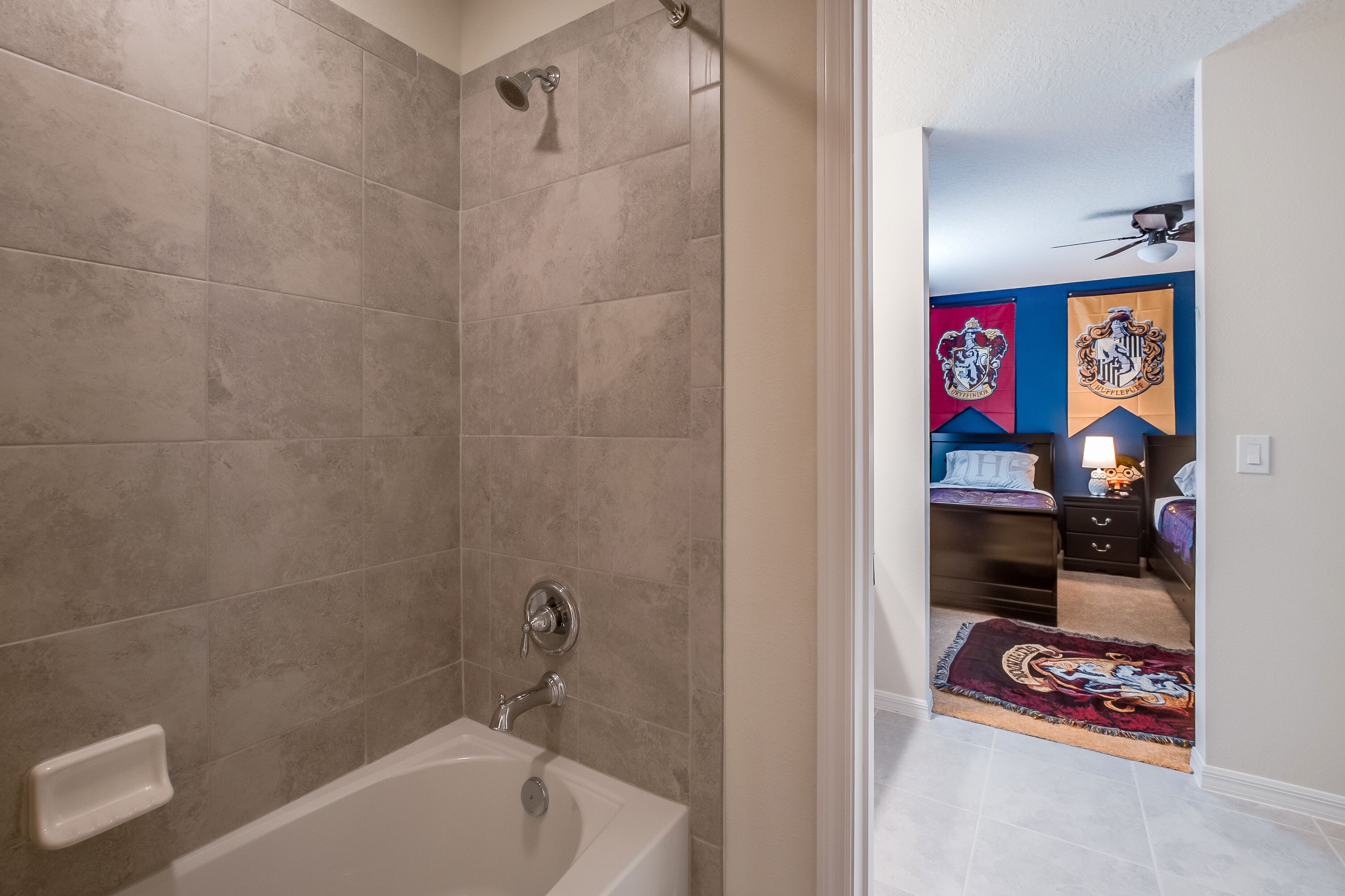 A bathroom with a bathtub, shower, and tiled walls.