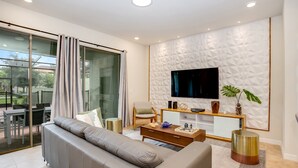 A modern living room with a sofa, TV, and a decorative wall. - 4582terra (Davenport)