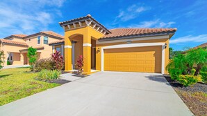 A residential house with a yellow facade, a tiled roof, and a garage. - 2509rose (Davenport)