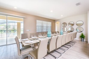 Un comedor con una mesa larga, sillas y una planta en maceta.