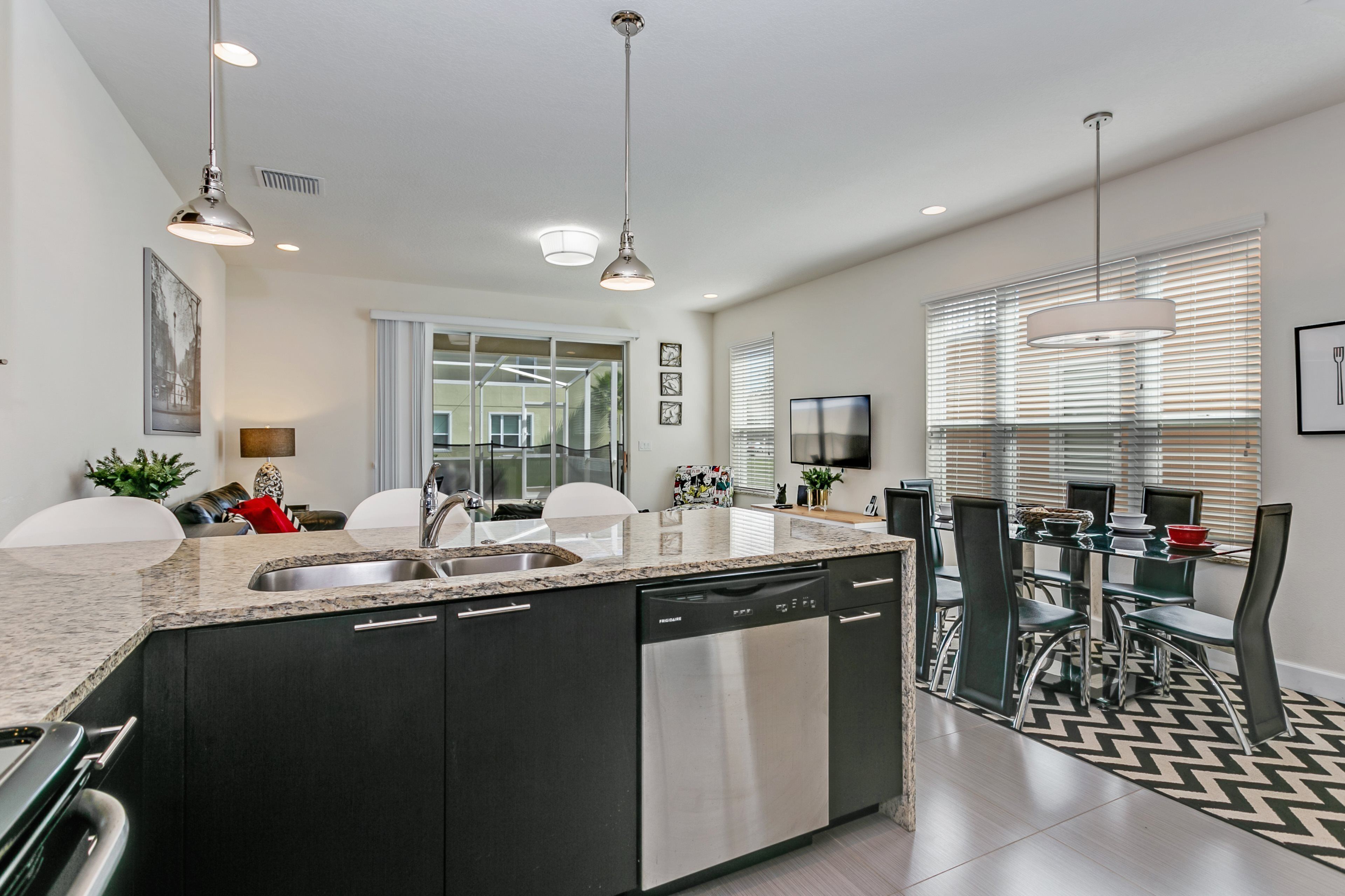 A modern kitchen with a central island, stainless steel appliances, and pendant lighting.