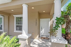A building entrance with white columns, a door marked "17331", and a window with blinds. - 17331serblvd (Clermont)