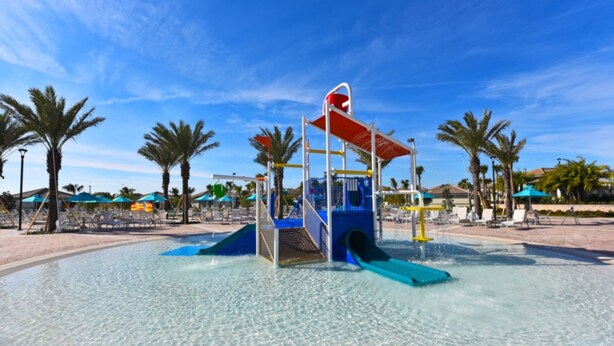 A water play area with slides and a climbing structure, surrounded by palm trees and beach chairs. - 6 Bedroom 5 Bathroom Vacation Home (Davenport)