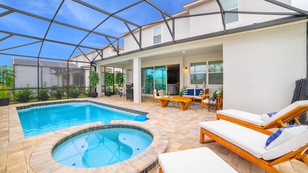 A swimming pool with a hot tub, lounge chairs, and a covered patio area. - 9 BD 6.5 BH With Pool, Spa and GR (Kissimmee)