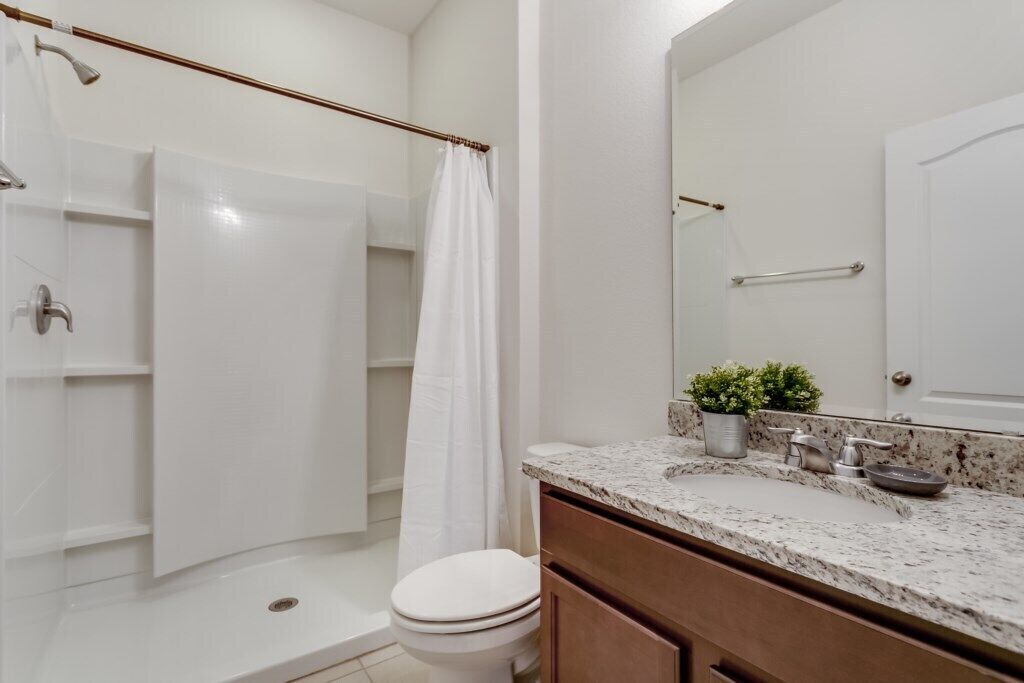 A bathroom with a shower, toilet, and sink.