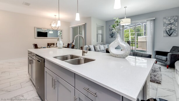 A modern kitchen with a large island, stainless steel appliances, and pendant lighting. - Relaxing 4bed 3Ba Champions Gate Pool (Davenport)