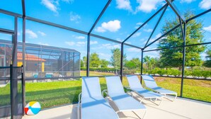 A covered outdoor area with lounge chairs and a beach ball. - 2521rose (Davenport)
