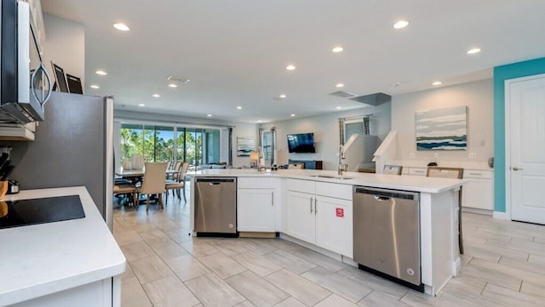 A modern kitchen with white cabinetry, stainless steel appliances, and a central island. - Encore Resort Villa W Private Pool and Spa 7670 (Kissimmee)