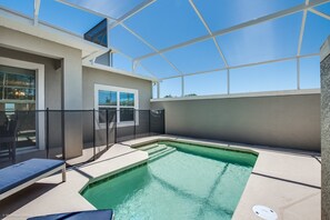 A covered outdoor swimming pool with lounge chairs, a glass enclosure, and a view of the surrounding area. - 910pb Luxury Furnished 5 Bedroom 5 Bathroom (Davenport)