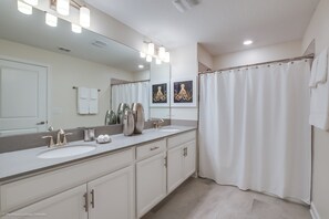 A bathroom with two sinks, a large mirror, and a shower curtain. - 910pb Luxury Furnished 5 Bedroom 5 Bathroom (Davenport)