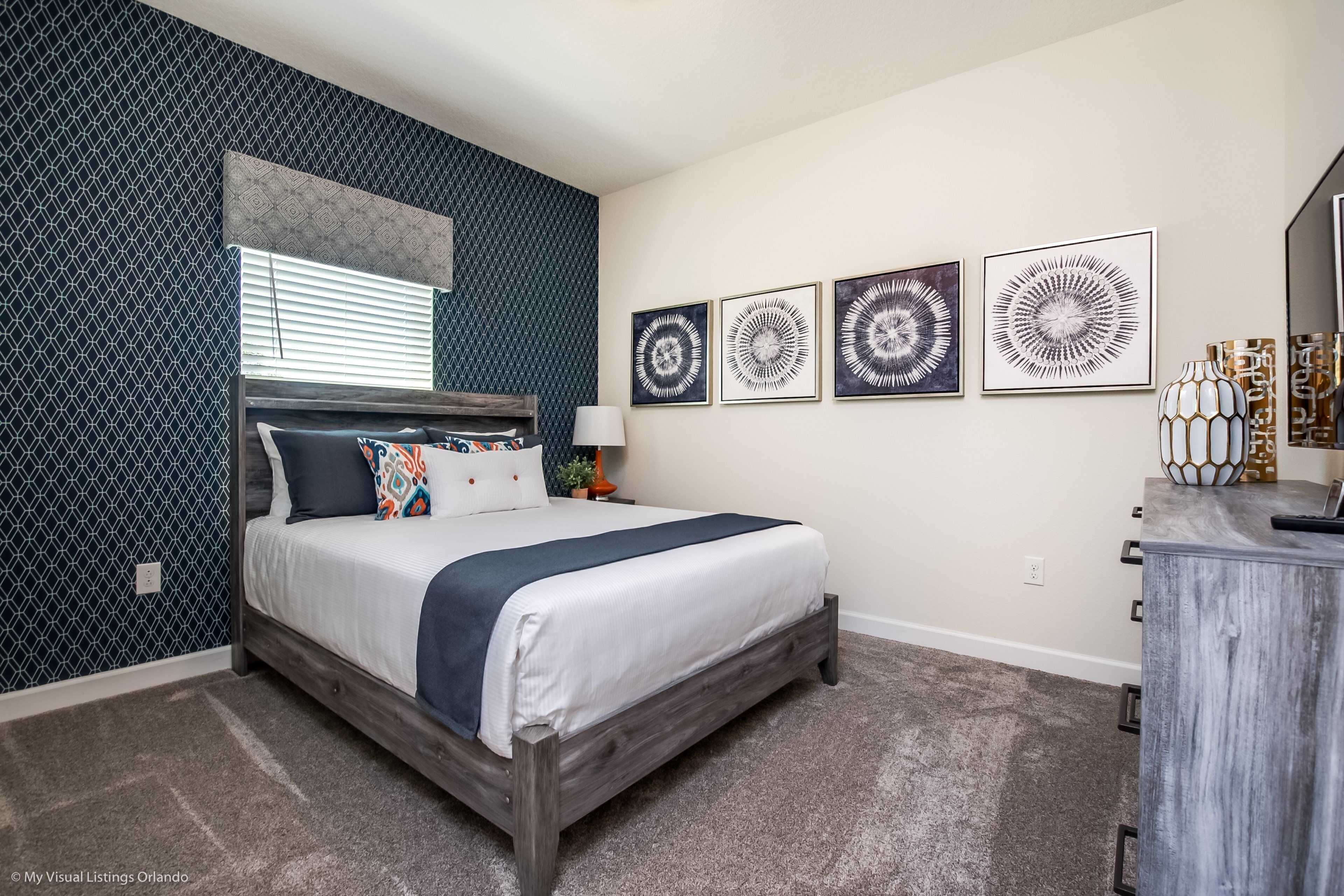 Un dormitorio con cama, cómoda y decoración en la pared.