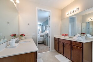 A modern bathroom with two sinks, a large mirror, and vanity cabinets. - Family Friendly 6bed 5Ba Villa Games Pool Spa 9039 (Kissimmee)