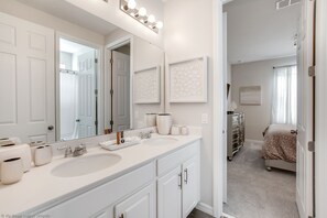 A bathroom with two sinks, a large mirror, and a vanity cabinet.