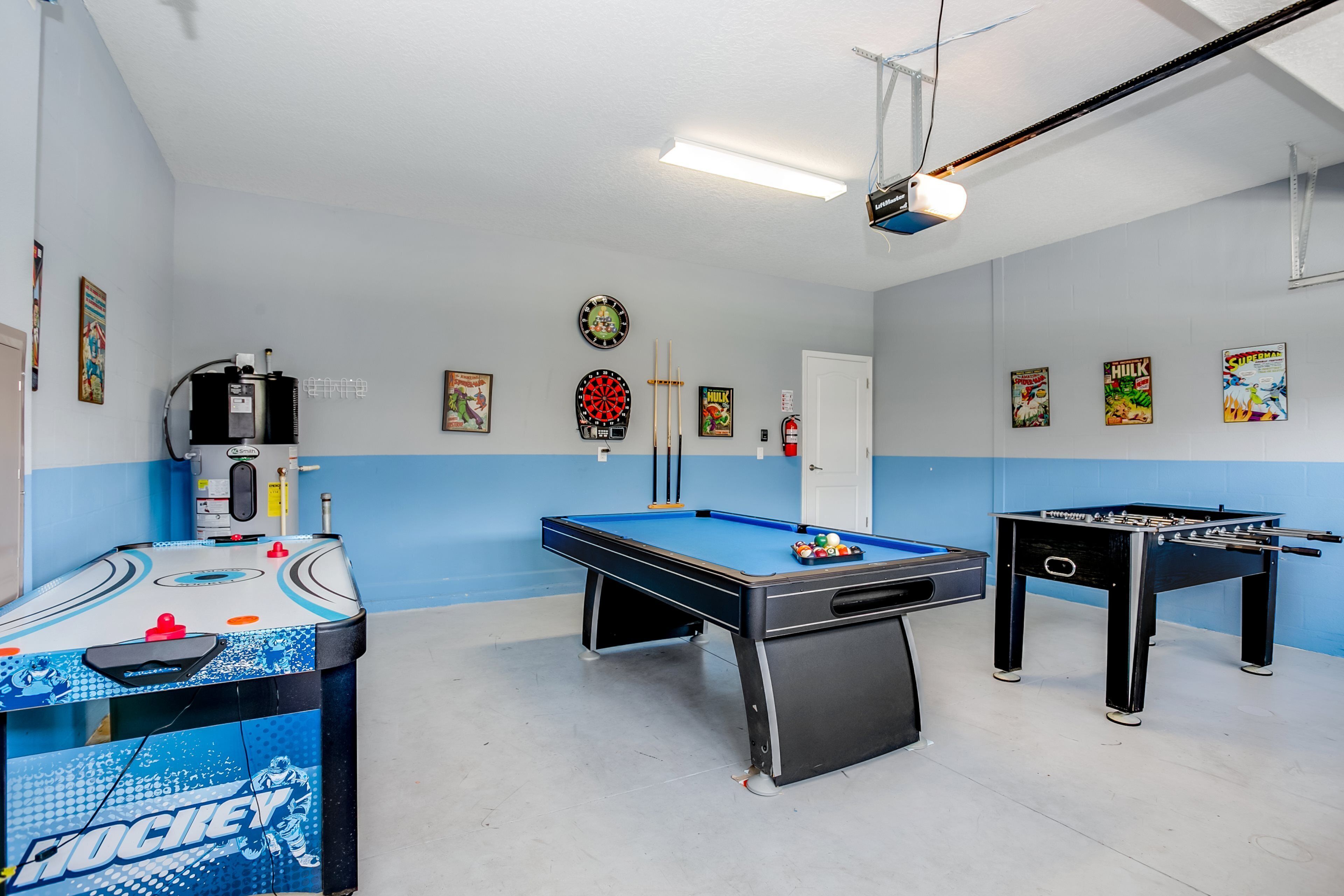 Una sala recreativa con mesa de billar, mesa de fútbol de mesa y jukebox.