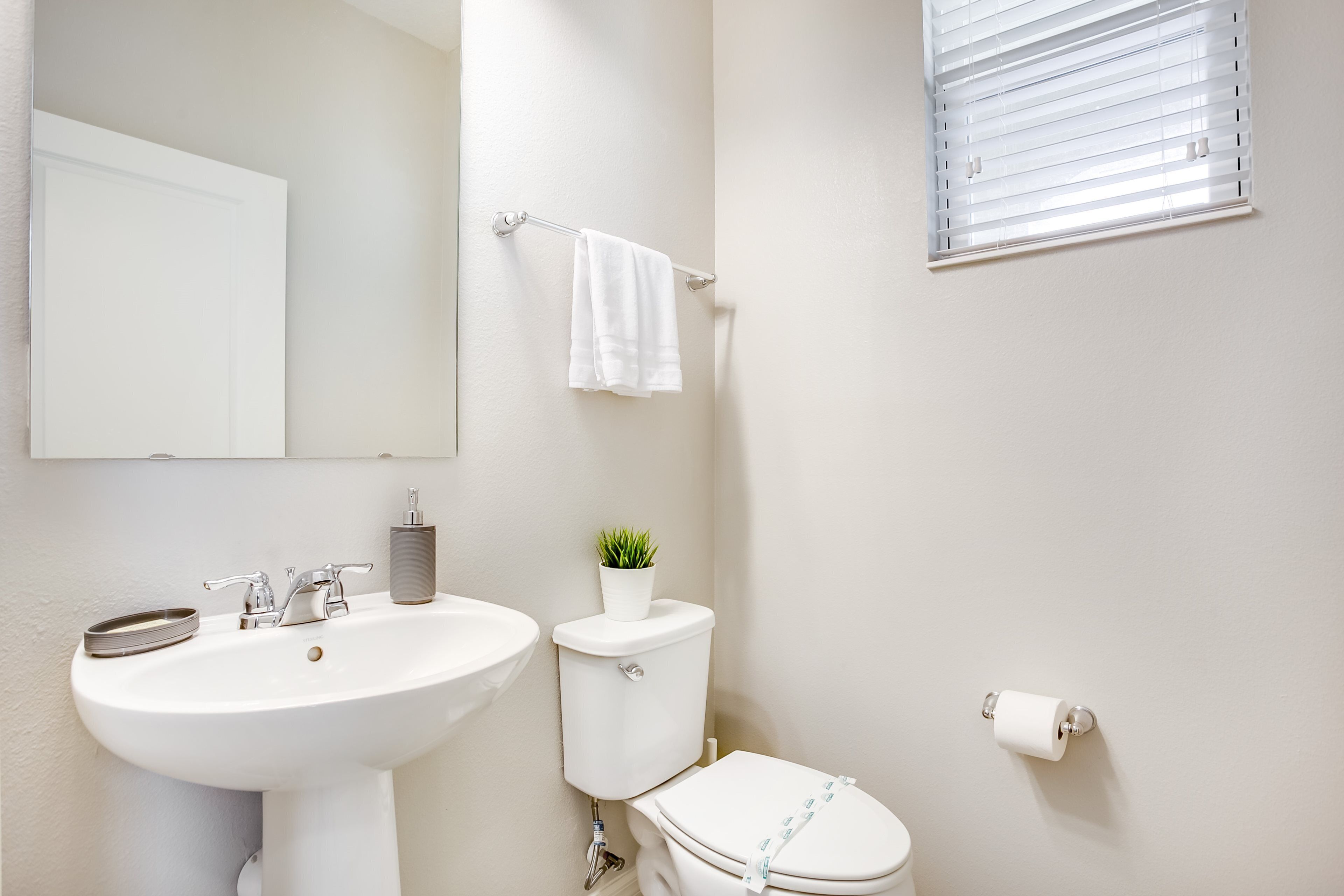 A bathroom with a white sink, toilet, and a towel rack.