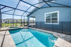 A swimming pool with a glass enclosure, a view of the neighborhood, and a covered patio area. - 9001fkw Amazing 7 Bedroom 5 Bathroom Solara (Kissimmee)