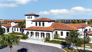 A white building with a tiled roof, a central tower, and a swimming pool in the background. - Lake View Villa (Kissimmee)