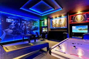 A gaming room with a foosball table, multiple screens, and a pool table. - 9 BD 6,5 BH Pool, Spa & Game Room (Kissimmee)