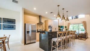 A modern kitchen with a central island, stainless steel appliances, and pendant lighting. - 3139brasillia (Kissimmee)