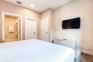 A bedroom with a large bed, a TV mounted on the wall, and a walk-in closet. - 3139brasillia (Kissimmee)